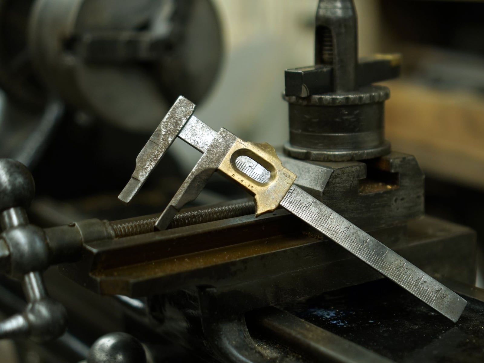 Präzise Messung eines gravierten Metallteils mit einem digitalen Messschieber.